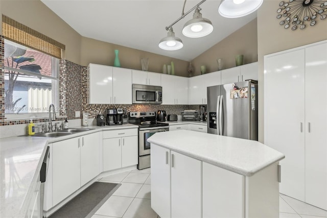 kitchen featuring sink, white cabinets, stainless steel appliances, and decorative light fixtures