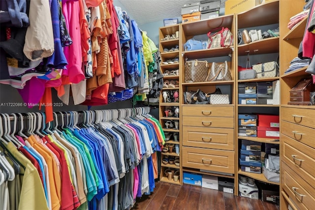 walk in closet with dark wood-type flooring