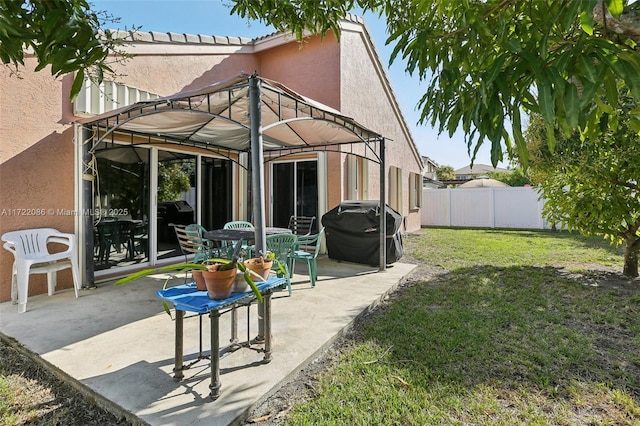 back of property featuring a gazebo, a patio area, and a lawn