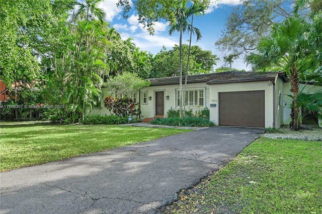 ranch-style house featuring a front yard and a garage