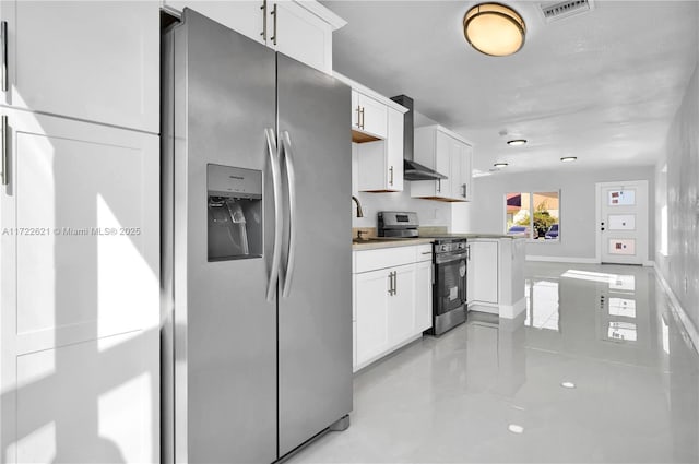 kitchen featuring kitchen peninsula, white cabinetry, wall chimney exhaust hood, and stainless steel appliances