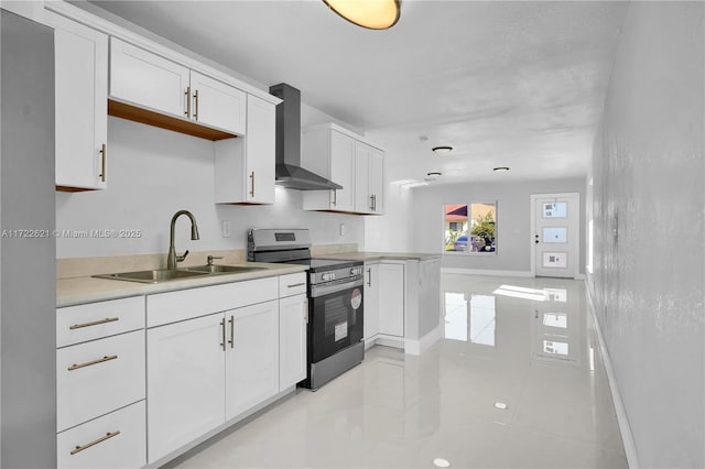 kitchen with white cabinetry, sink, wall chimney range hood, stainless steel range oven, and kitchen peninsula