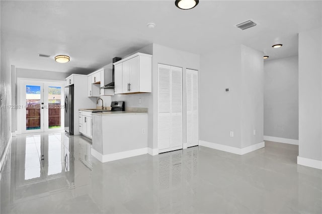 kitchen featuring white cabinetry, stainless steel fridge, sink, and french doors