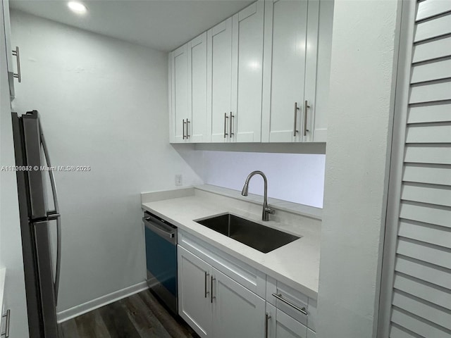 kitchen featuring white cabinetry, sink, appliances with stainless steel finishes, and dark wood-type flooring