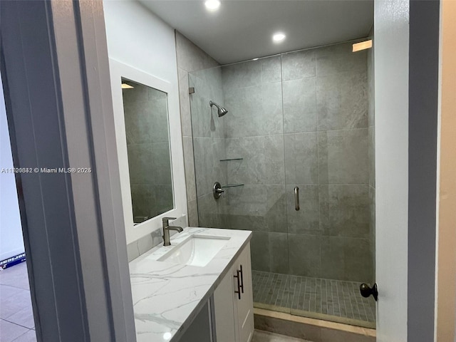 bathroom featuring tile patterned floors, vanity, and a shower with shower door