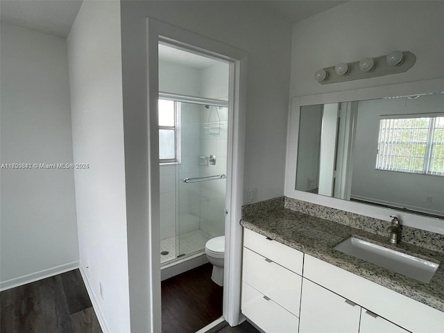 bathroom with walk in shower, hardwood / wood-style flooring, vanity, and toilet