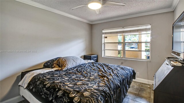 bedroom featuring ornamental molding, ceiling fan, dark tile patterned floors, and a textured ceiling