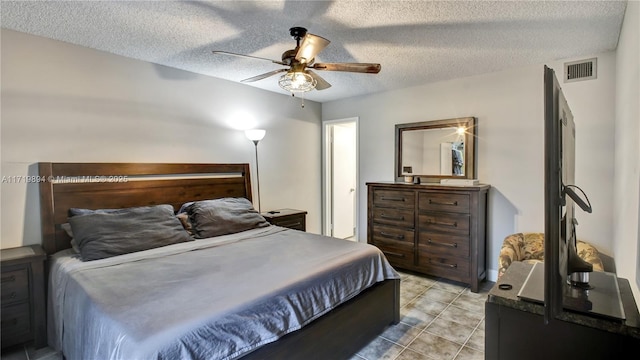 bedroom with ceiling fan and a textured ceiling