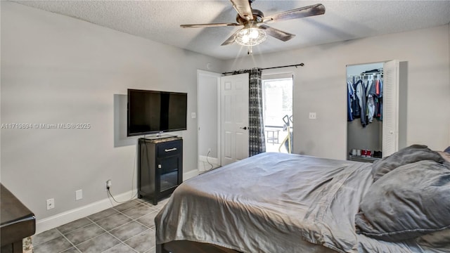 tiled bedroom with a textured ceiling, a closet, and ceiling fan