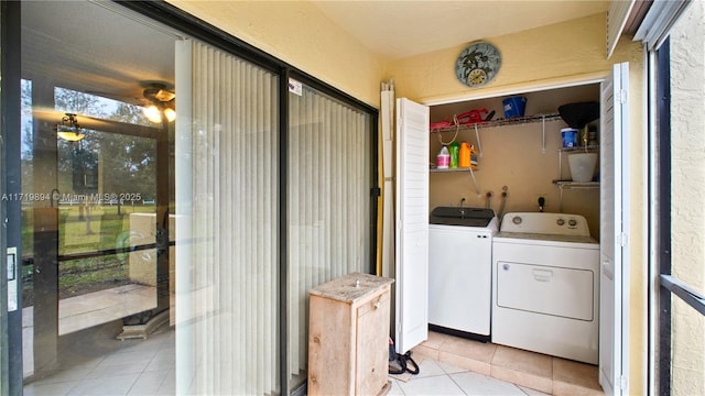 clothes washing area with light tile patterned flooring and washing machine and dryer