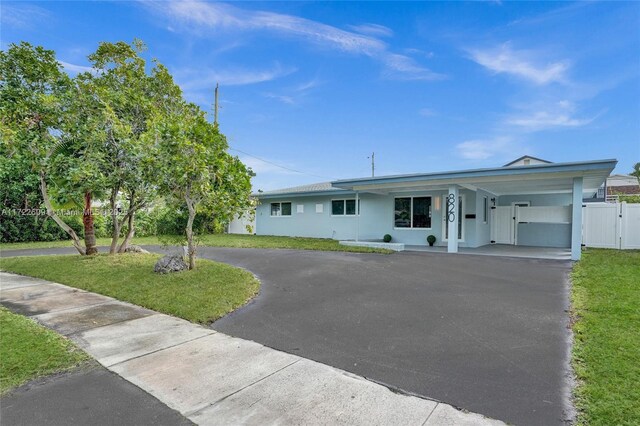 ranch-style house with a carport and a front lawn