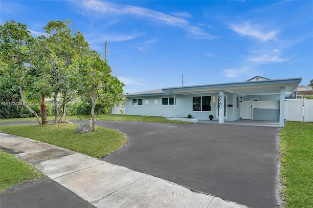 ranch-style home featuring a front lawn and a carport