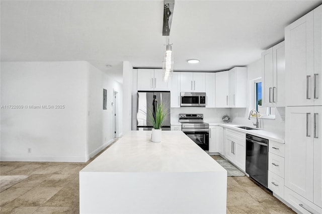 kitchen with pendant lighting, sink, a kitchen island, and appliances with stainless steel finishes