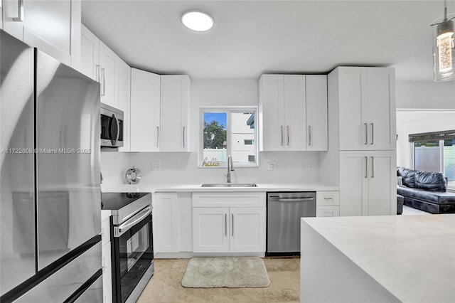 kitchen featuring appliances with stainless steel finishes, sink, and white cabinets