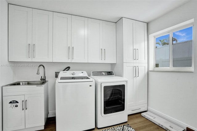 laundry room with separate washer and dryer, sink, dark wood-type flooring, and cabinets