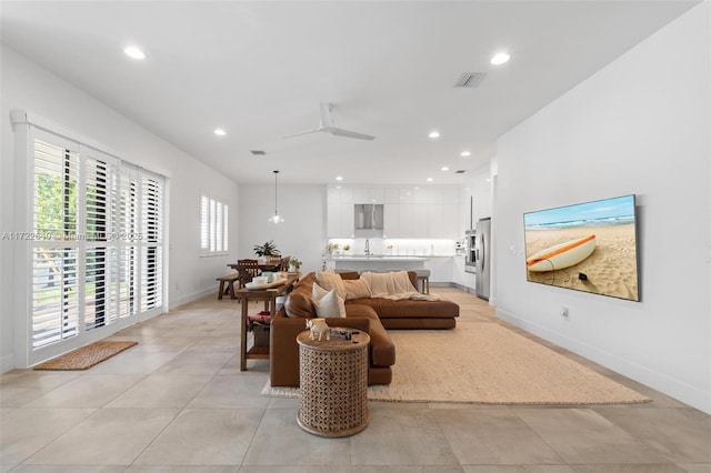 living room with ceiling fan and sink