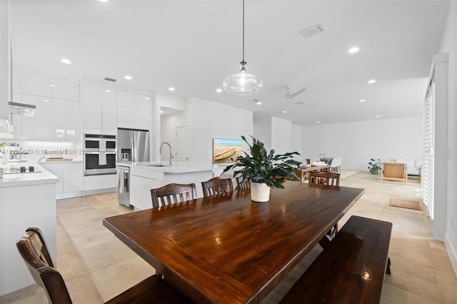 dining room with ceiling fan, sink, and light tile patterned flooring