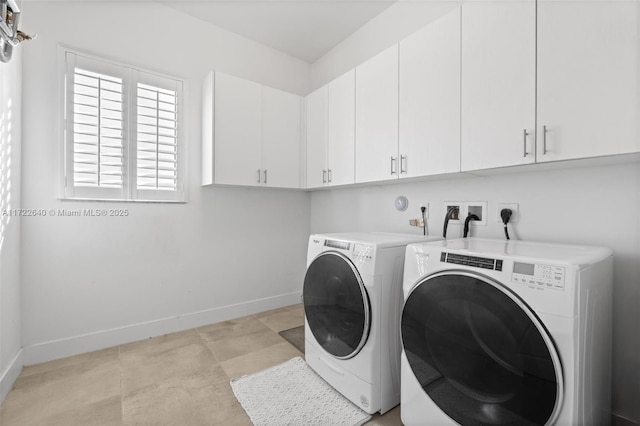 washroom featuring cabinets and washing machine and dryer