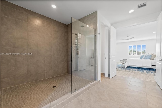 bathroom with ceiling fan, tile patterned flooring, and tiled shower