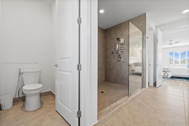 bathroom with tiled shower, ceiling fan, tile patterned flooring, and toilet