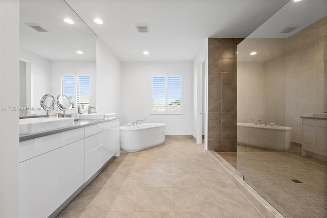 bathroom with tile patterned floors, vanity, and plus walk in shower