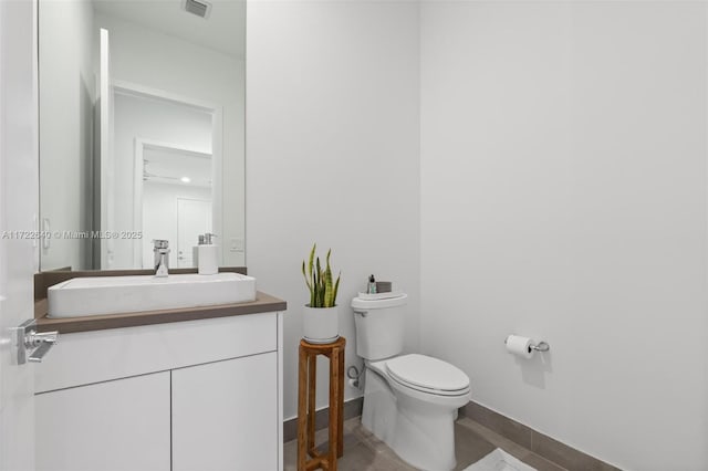 bathroom featuring tile patterned flooring, vanity, and toilet