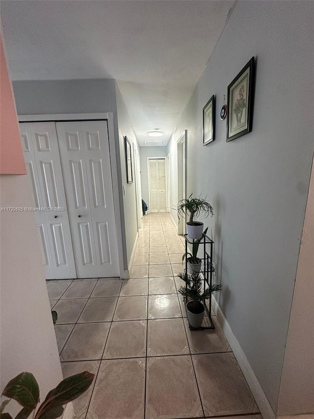 corridor with light tile patterned flooring