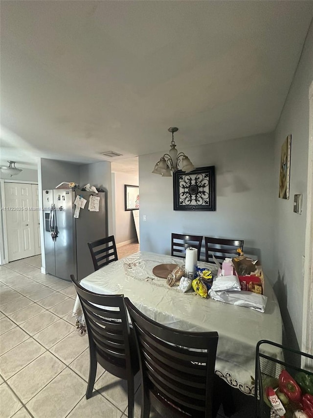 dining space featuring a notable chandelier and light tile patterned flooring