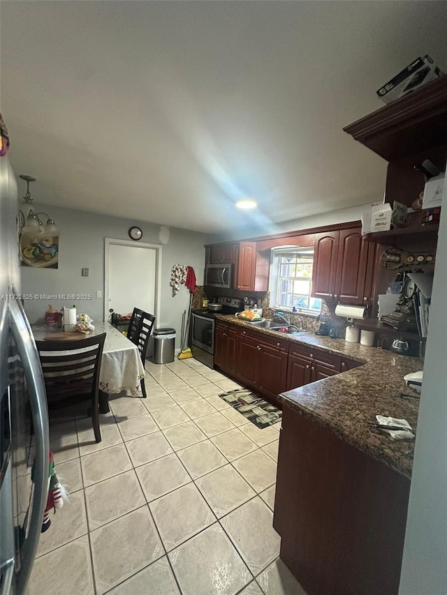 kitchen with sink, light tile patterned floors, and stainless steel appliances