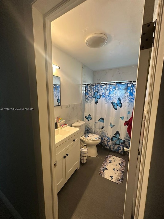 bathroom featuring vanity, toilet, tile walls, and a shower with shower curtain