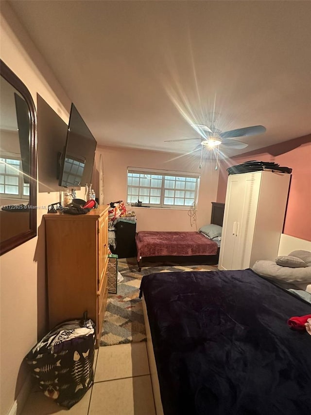 tiled bedroom featuring ceiling fan