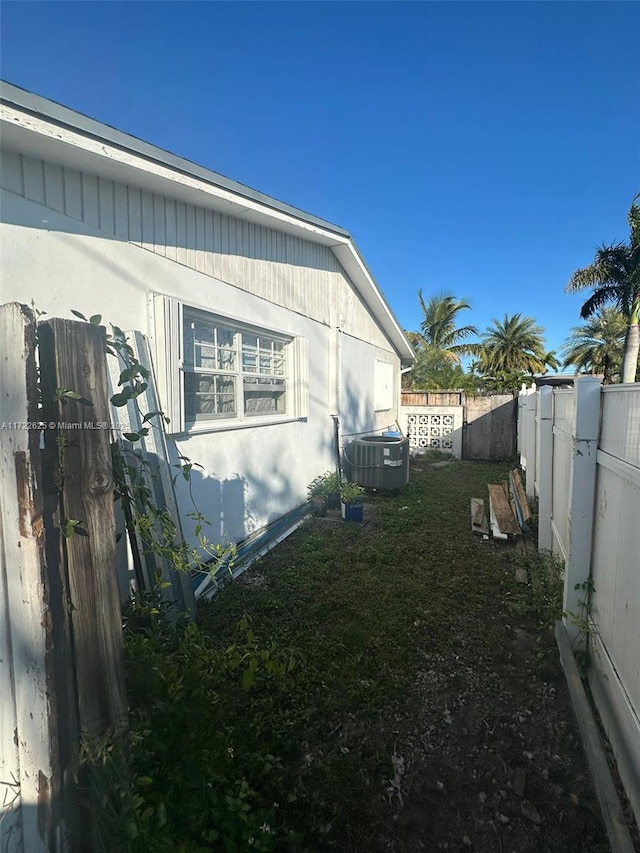 view of property exterior featuring central air condition unit and a yard