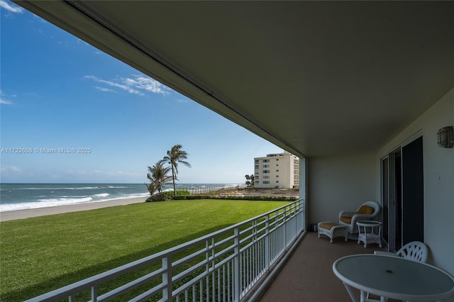 balcony featuring a water view and a view of the beach