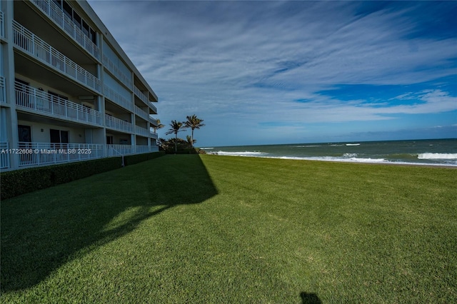 view of yard featuring a beach view and a water view