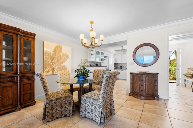 tiled dining area with ceiling fan with notable chandelier and crown molding