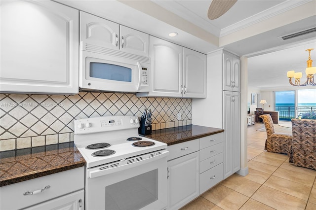 kitchen with white appliances, white cabinetry, a notable chandelier, and light tile patterned flooring