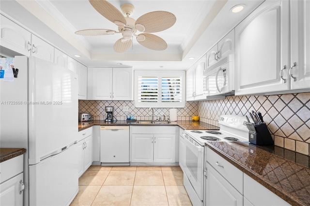 kitchen with white appliances, a raised ceiling, ceiling fan, white cabinets, and light tile patterned flooring