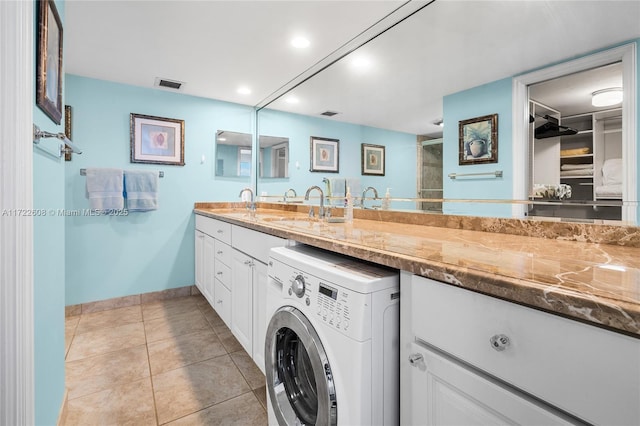 bathroom featuring tile patterned flooring, vanity, and washer / clothes dryer