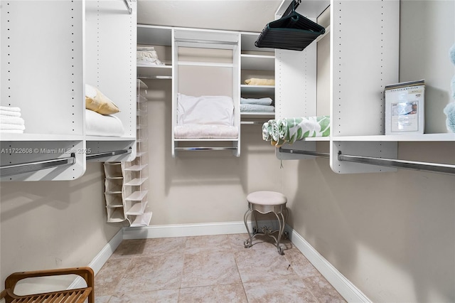 walk in closet with light tile patterned floors