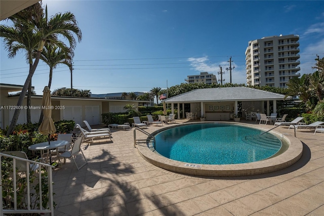 view of swimming pool featuring an outdoor structure and a patio area