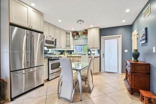 kitchen with light tile patterned flooring and appliances with stainless steel finishes