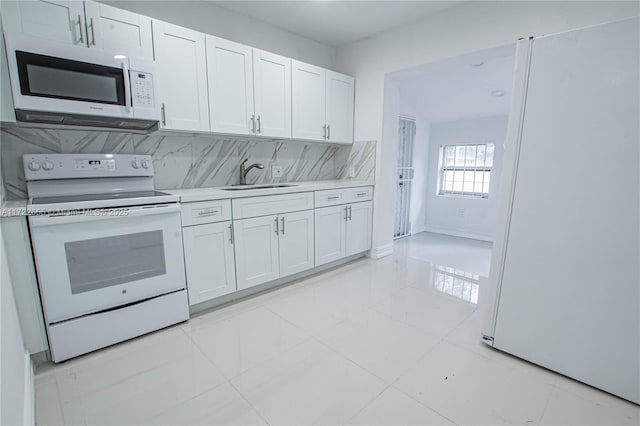 kitchen with backsplash, white cabinetry, white appliances, and sink