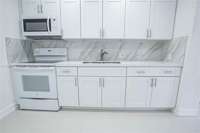 kitchen featuring white appliances, backsplash, white cabinets, sink, and light tile patterned floors