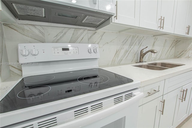 kitchen with tasteful backsplash, electric range, sink, and white cabinets