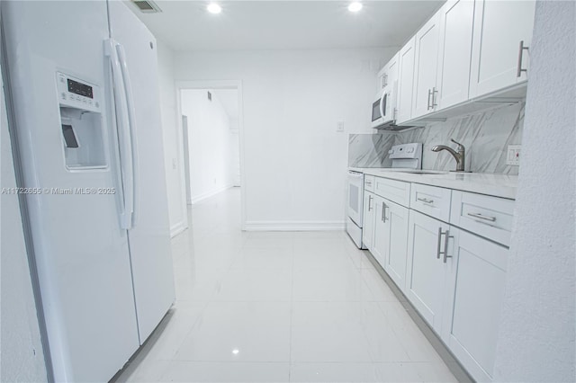 kitchen featuring backsplash, white cabinetry, sink, and white appliances