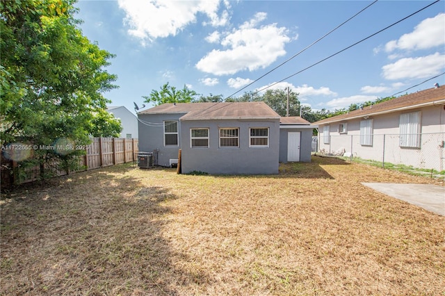 back of house featuring central AC and a yard