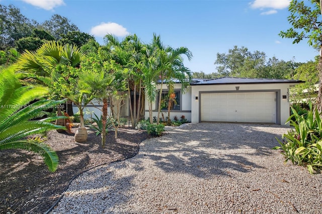 1511 SW 30th Pl, Fort Lauderdale, FL 33315 - view of front facade featuring gravel driveway, stucco siding, and an attached garage