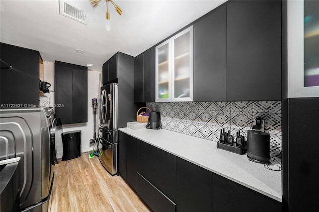 kitchen featuring backsplash, stainless steel fridge, and light wood-type flooring