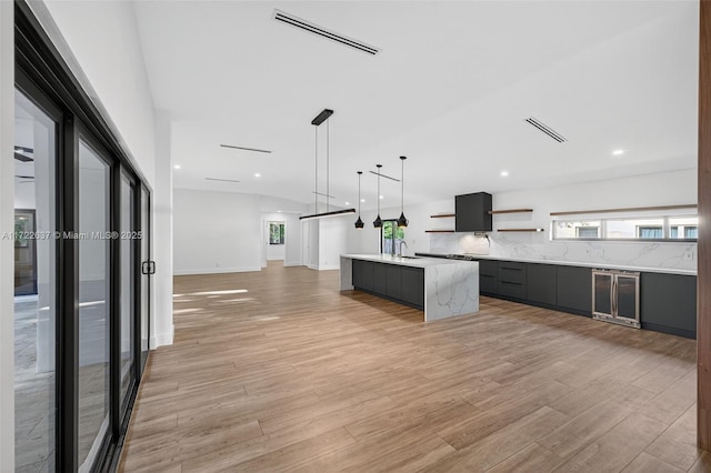 1511 SW 30th Pl, Fort Lauderdale, FL 33315 - kitchen with modern cabinets, wine cooler, open shelves, light countertops, and tasteful backsplash