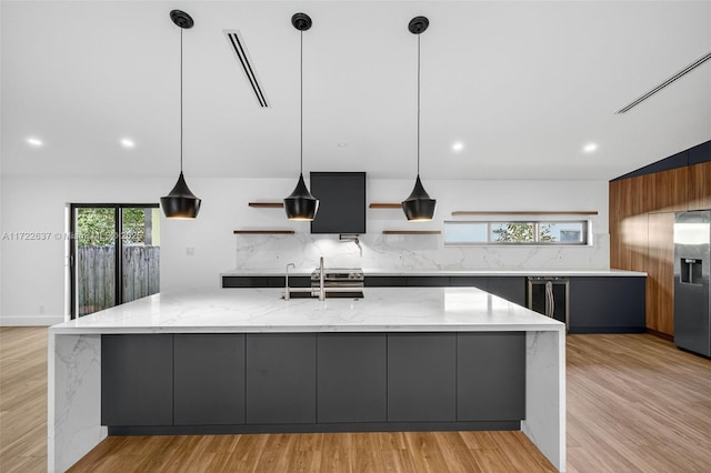 1511 SW 30th Pl, Fort Lauderdale, FL 33315 - kitchen with modern cabinets, tasteful backsplash, a large island, light wood-style floors, and light stone countertops
